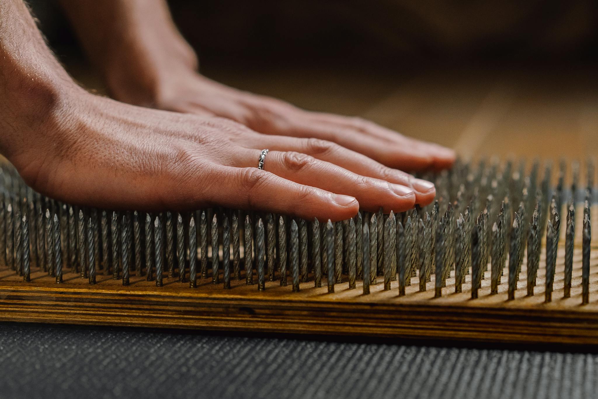 Close-up of hands on a sadhu board for meditation practice, promoting calmness.